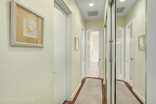 hallway featuring recessed lighting, visible vents, and baseboards