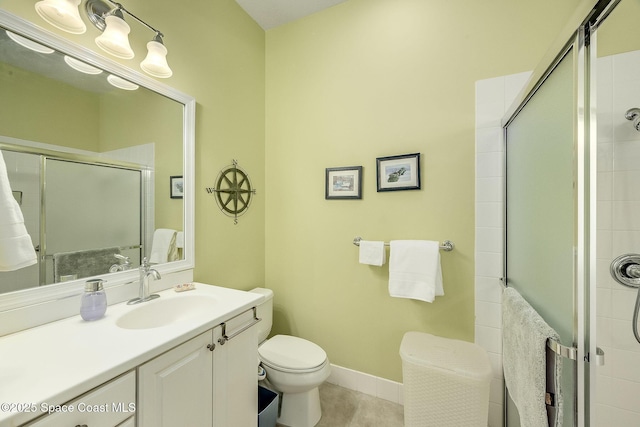 full bathroom featuring a shower stall, baseboards, toilet, tile patterned floors, and vanity