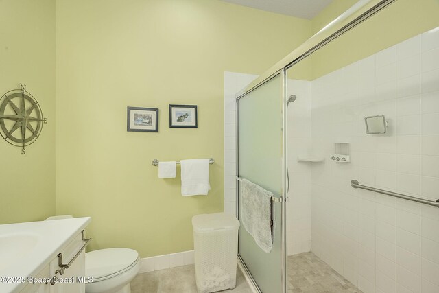 full bathroom with toilet, a stall shower, tile patterned flooring, baseboards, and vanity