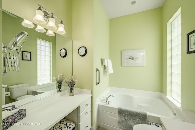 full bathroom with toilet, a bath, and vanity