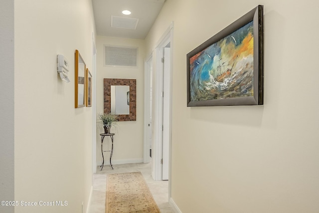 hallway featuring baseboards and visible vents