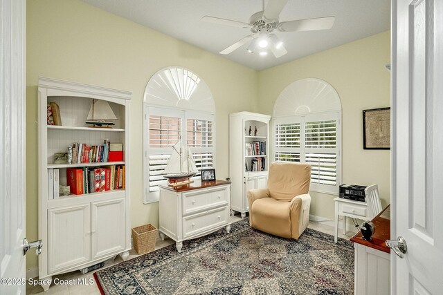 living area featuring a ceiling fan and tile patterned flooring