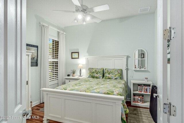 bedroom featuring visible vents, dark wood finished floors, and access to exterior