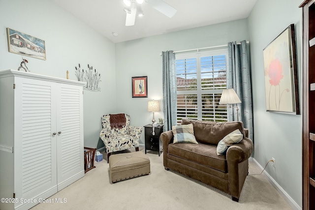 living area with baseboards, carpet floors, and ceiling fan