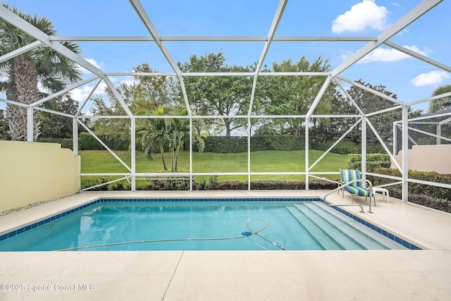 pool with a yard, glass enclosure, and a patio area