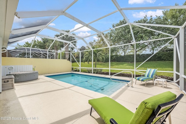 outdoor pool with a patio area, glass enclosure, and a yard