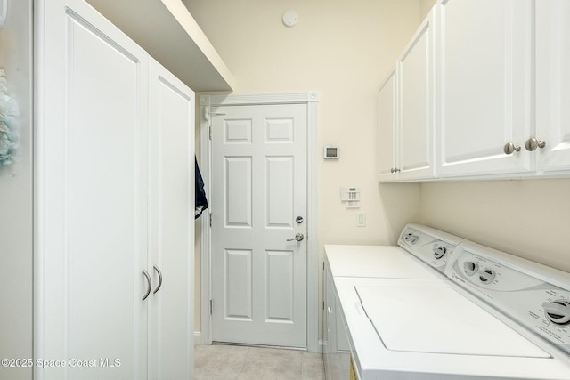 laundry area with cabinet space, independent washer and dryer, and light tile patterned flooring