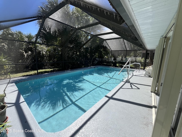 outdoor pool featuring glass enclosure and a patio area