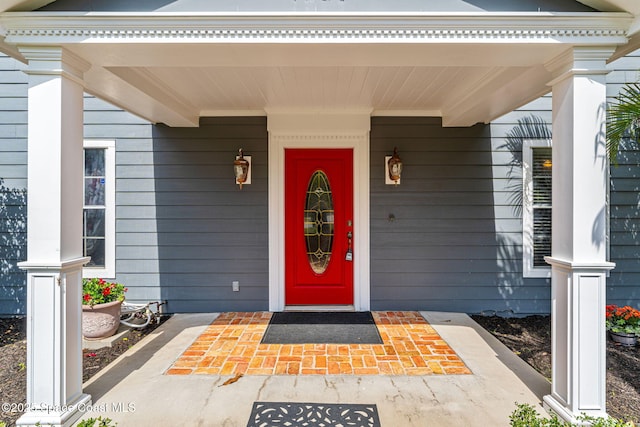 property entrance featuring covered porch and uncovered parking