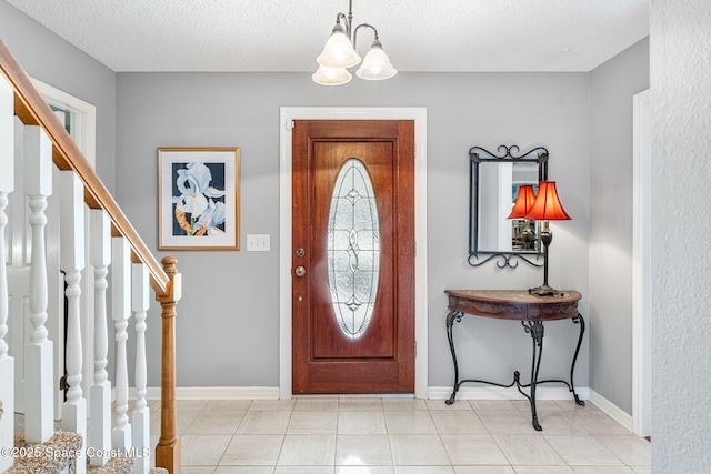 foyer with an inviting chandelier, baseboards, stairway, and a textured ceiling