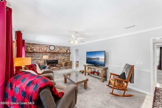 living room with a textured ceiling, ceiling fan, visible vents, ornamental molding, and a brick fireplace