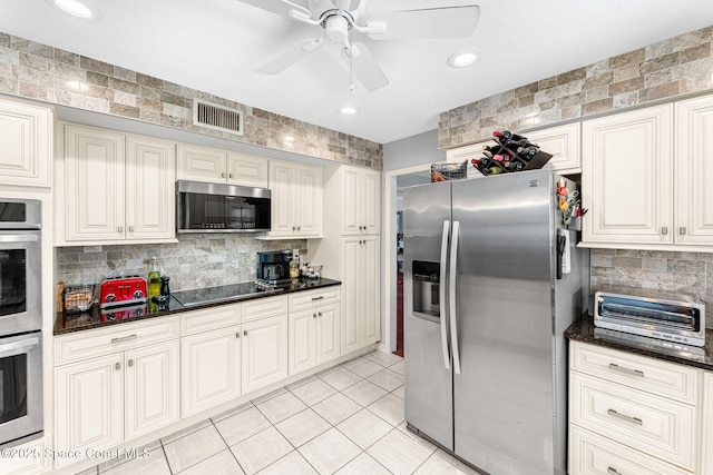 kitchen featuring light tile patterned floors, stainless steel appliances, visible vents, a ceiling fan, and backsplash