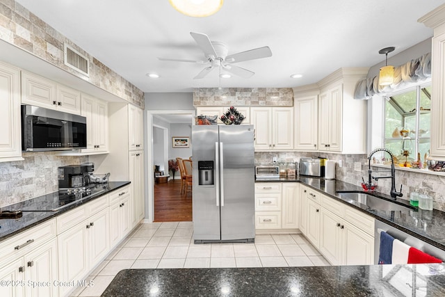 kitchen with appliances with stainless steel finishes, visible vents, a sink, and light tile patterned flooring