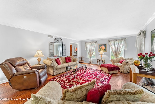 living room with baseboards, visible vents, wood finished floors, and ornamental molding