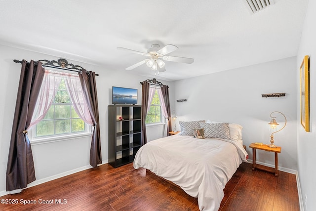 bedroom featuring a ceiling fan, baseboards, visible vents, and wood finished floors