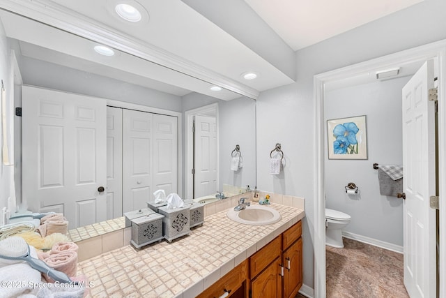 bathroom with recessed lighting, vanity, toilet, and baseboards