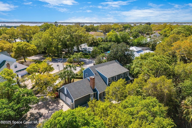 bird's eye view with a water view and a wooded view