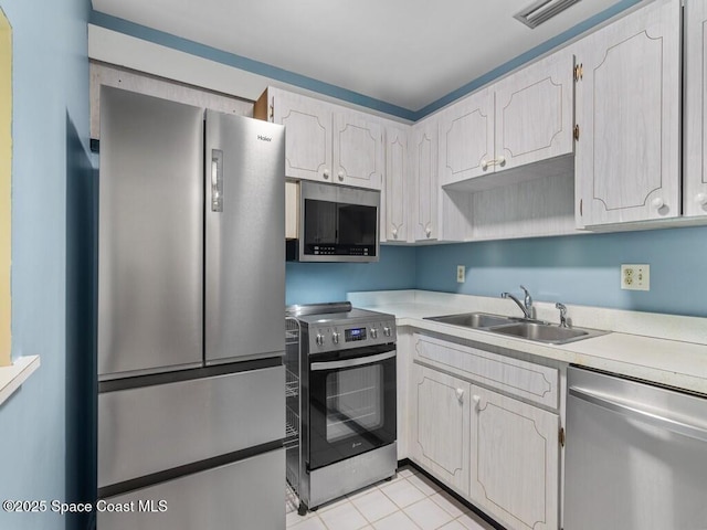 kitchen featuring stainless steel appliances, light countertops, visible vents, and a sink