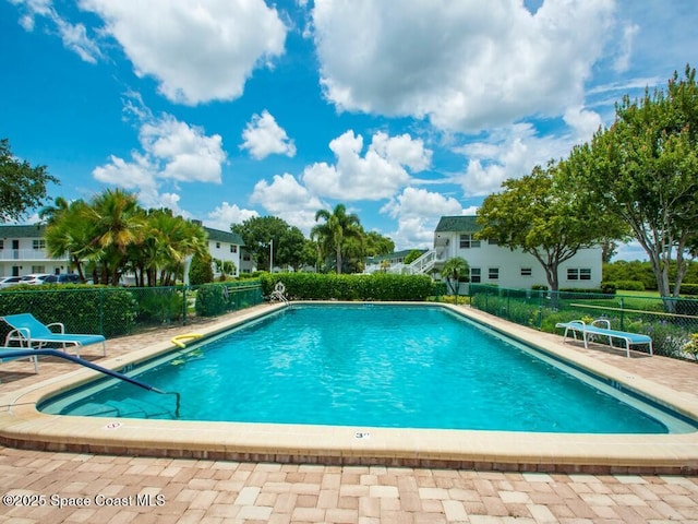 community pool featuring fence and a patio