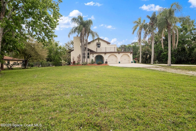 mediterranean / spanish home featuring a garage, driveway, stucco siding, a front lawn, and a chimney