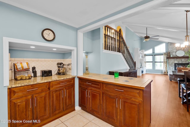 kitchen with brown cabinets, vaulted ceiling with beams, decorative backsplash, ceiling fan, and a peninsula