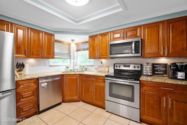 kitchen featuring stainless steel appliances, brown cabinetry, a sink, and light tile patterned floors