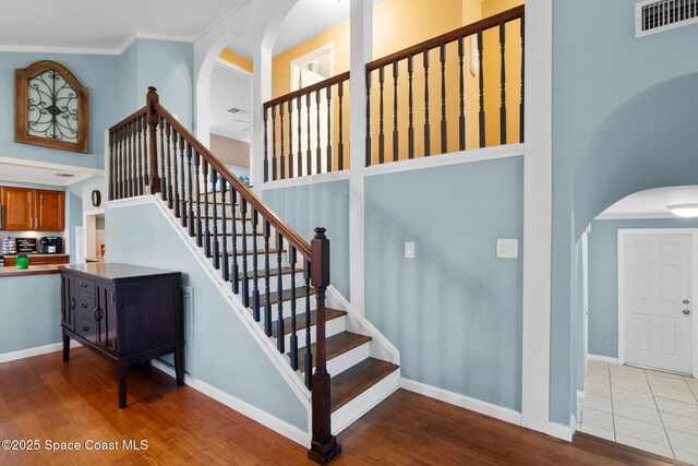 stairway with visible vents, baseboards, and wood finished floors