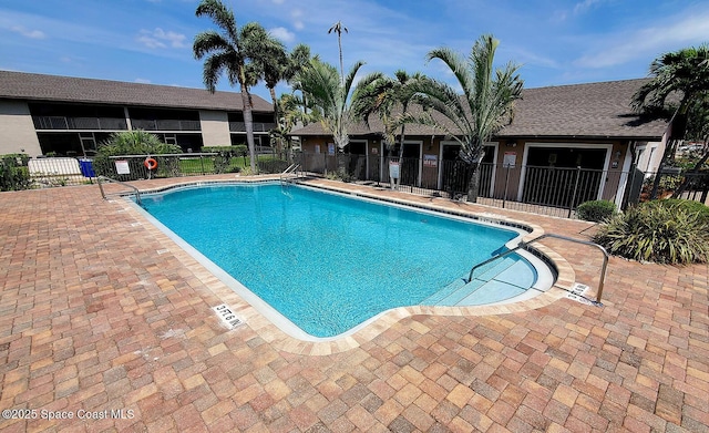 community pool featuring a patio and fence