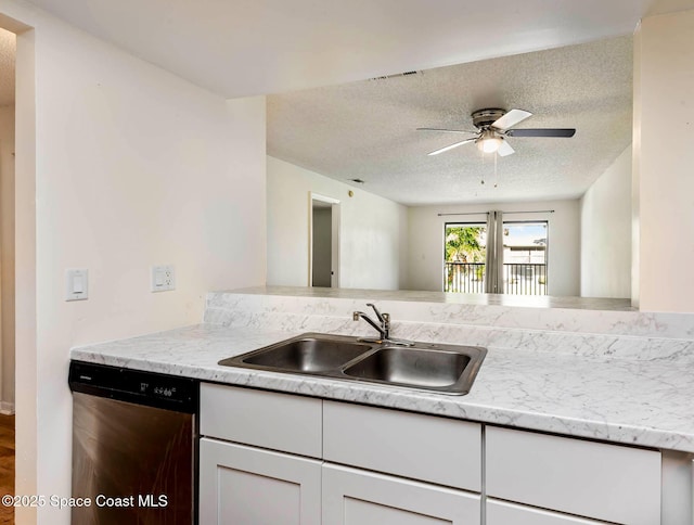 kitchen featuring a textured ceiling, a sink, visible vents, white cabinetry, and stainless steel dishwasher