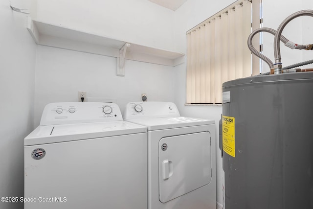 laundry area with laundry area, electric water heater, and washer and dryer