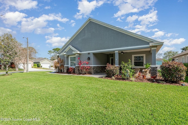 craftsman house with a ceiling fan, a front yard, and stucco siding