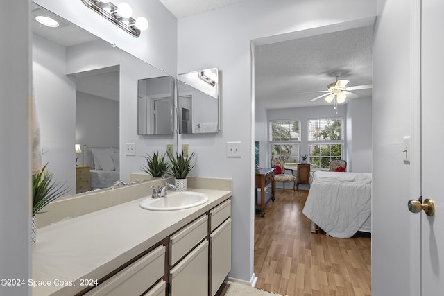 bathroom featuring a textured ceiling, wood finished floors, connected bathroom, and a ceiling fan