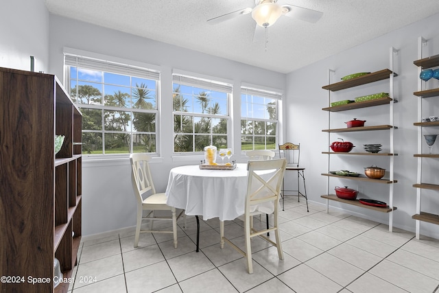 dining area featuring a textured ceiling, light tile patterned flooring, and a ceiling fan