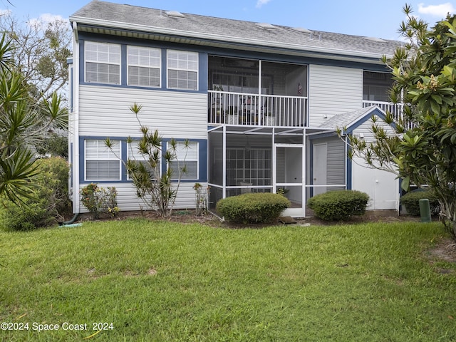 back of property featuring a sunroom and a yard