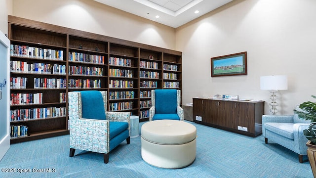 living area featuring carpet, bookshelves, and recessed lighting