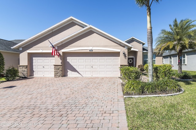 ranch-style home featuring a garage, stone siding, decorative driveway, and stucco siding