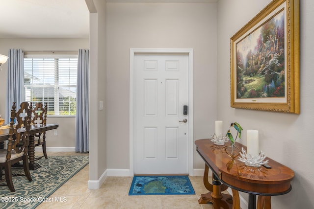 entryway with light tile patterned floors and baseboards