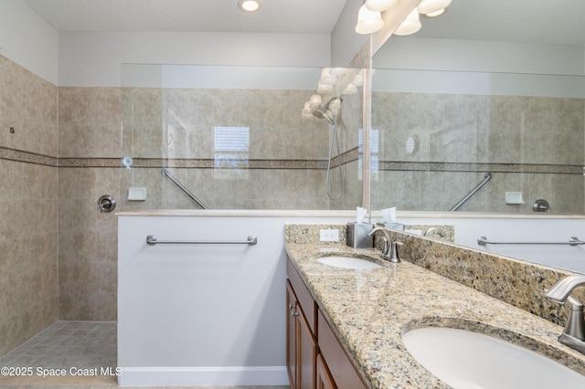 bathroom with a walk in shower, double vanity, and a sink