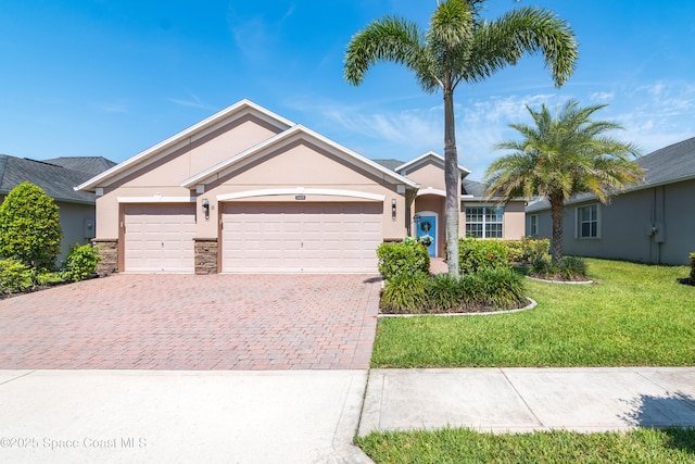 3485 Sansome Cir, Melbourne, FL 32940 - single story home featuring stucco siding, decorative driveway, an attached garage, a front lawn, and stone siding