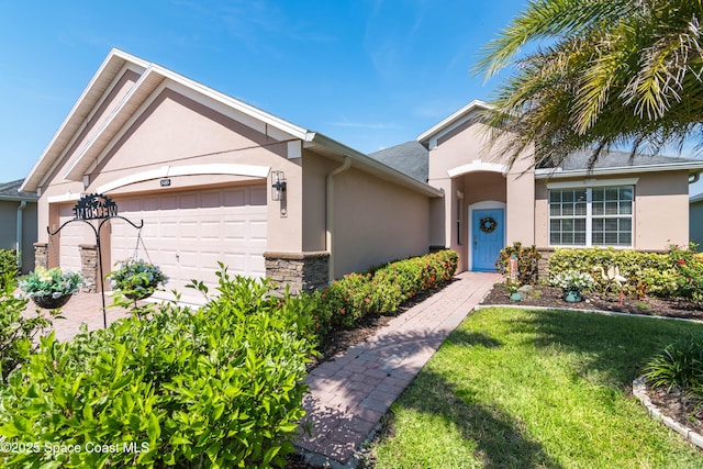 3485 Sansome Cir, Melbourne, FL 32940 - view of front of house with stucco siding, an attached garage, stone siding, and a front lawn