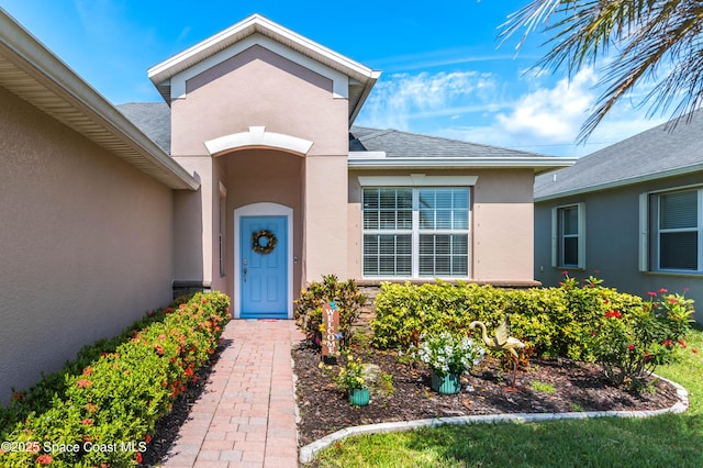 3485 Sansome Cir, Melbourne, FL 32940 - doorway to property with stucco siding and a shingled roof