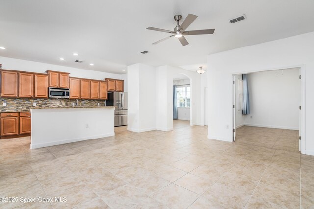 3485 Sansome Cir, Melbourne, FL 32940 - kitchen with stainless steel appliances, arched walkways, a ceiling fan, recessed lighting, and backsplash