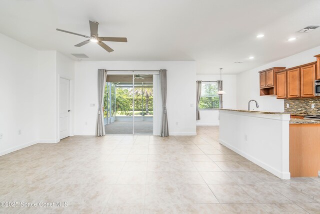 3485 Sansome Cir, Melbourne, FL 32940 - kitchen with a ceiling fan, brown cabinetry, tasteful backsplash, recessed lighting, and light tile patterned floors