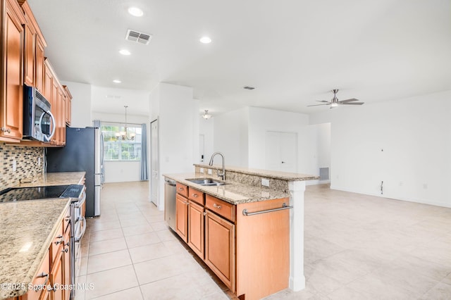 3485 Sansome Cir, Melbourne, FL 32940 - kitchen featuring appliances with stainless steel finishes, a sink, a center island with sink, brown cabinets, and ceiling fan