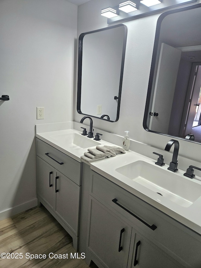 bathroom featuring baseboards, wood finished floors, and vanity