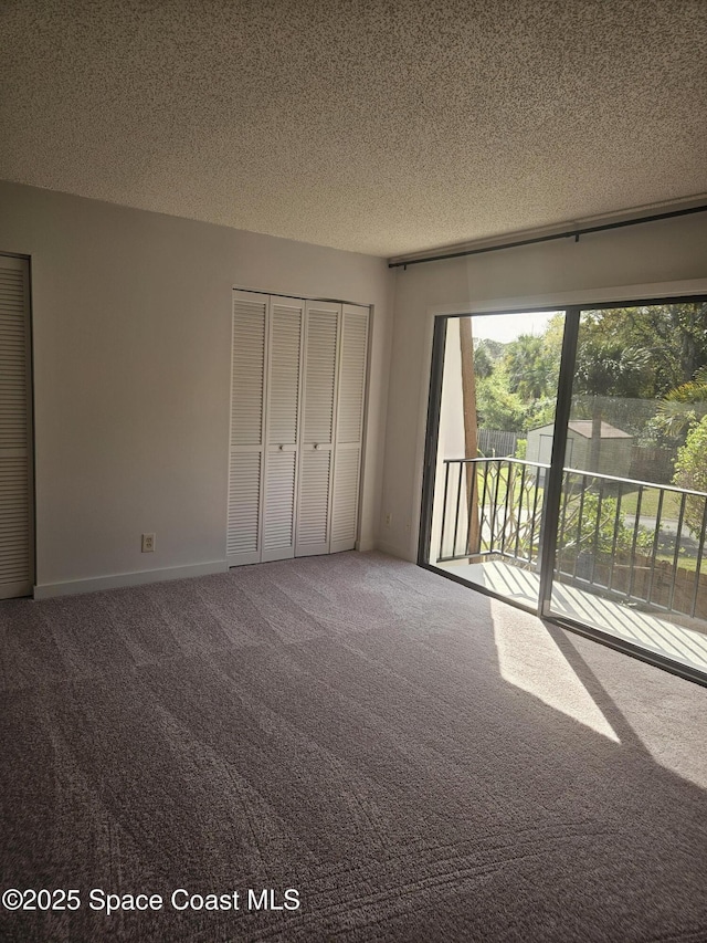 unfurnished bedroom with access to exterior, carpet, a closet, and a textured ceiling