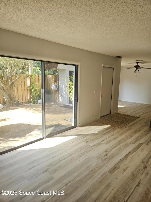 unfurnished room with a ceiling fan, a textured ceiling, and wood finished floors