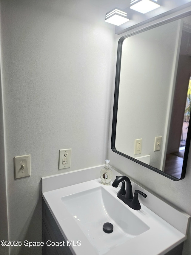 bathroom featuring a textured wall and vanity