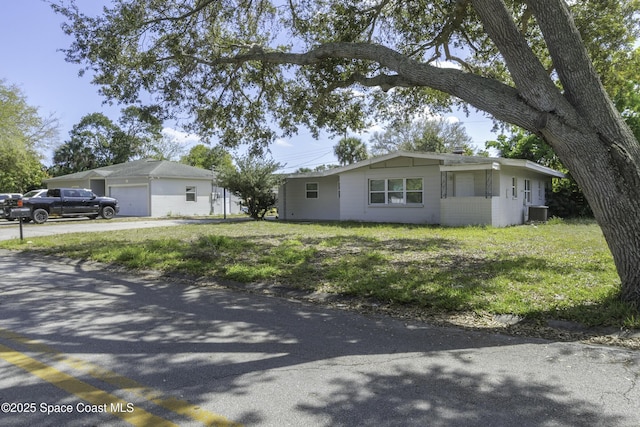 ranch-style home featuring central AC unit, concrete block siding, and a front yard