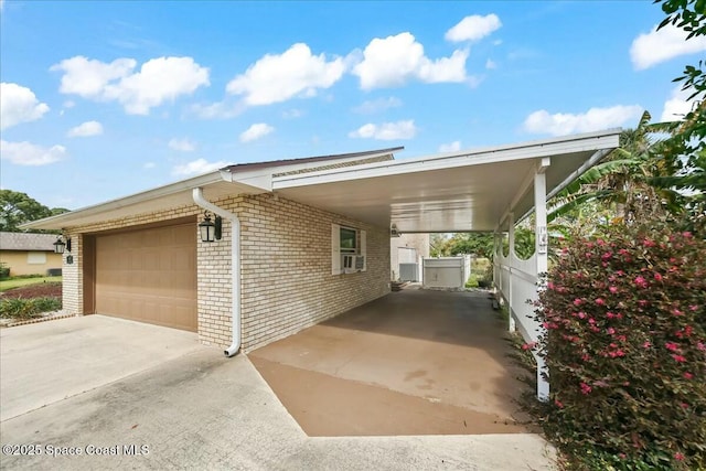 exterior space with a garage, a carport, brick siding, and driveway